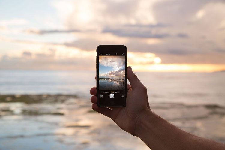 Affiliate tar kort med sin mobiltelefon på solnedgång.